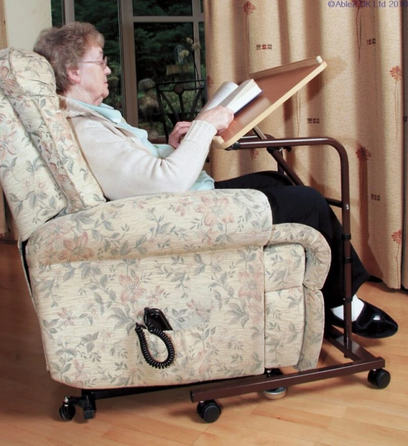 Person using an over armchair table while seated in a recliner.