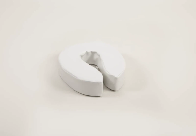 White padded raised toilet seat on a light background.
