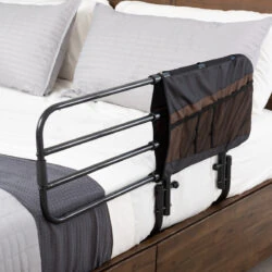Bed rail with attached pouch on a wooden bed frame.