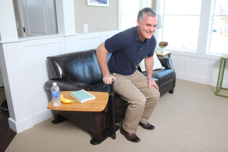 Man using a swivel table attached to a recliner.
