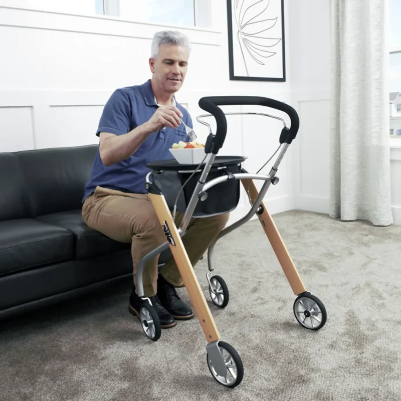 Man sitting on a couch using a rollator with a tray.