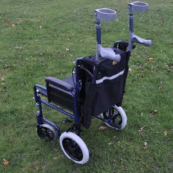 Mobility scooter bag with crutch holder attached to a wheelchair on grass.