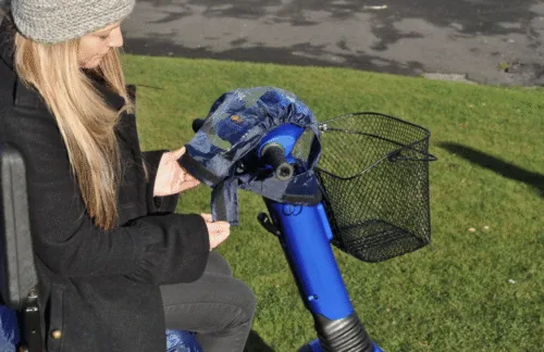 Person fitting a cover on a mobility scooter control panel.