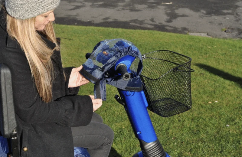 Person fitting a cover on a mobility scooter control panel.