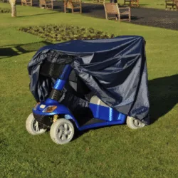 Blue mobility scooter with navy rain cover on grass