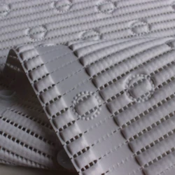 Close-up of white anti-slip bath mat with textured circles and lines.