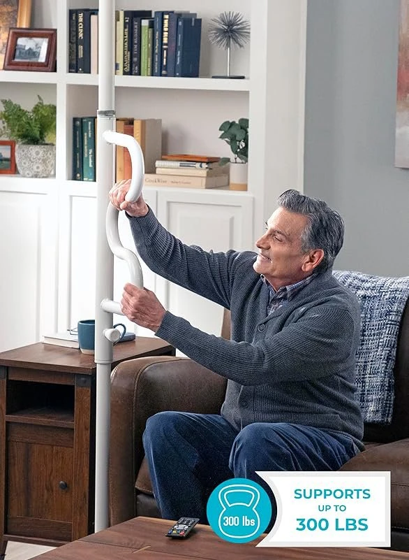 Man using a white security pole with a curved grab bar in a living room.