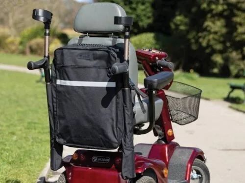 Black mobility scooter bag with crutch holder attached to a red scooter.