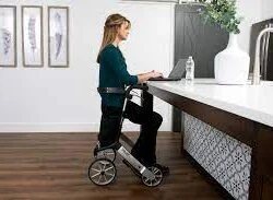 Person sitting on a Lets Go Out Rollator at a kitchen counter.