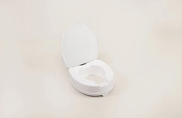 White elevated toilet seat with lid in open position.
