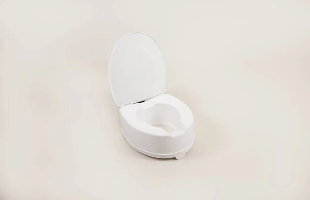 White toilet raiser seat with lid on a plain background.