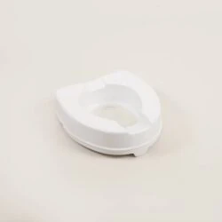 White toilet raiser seat on a light background.