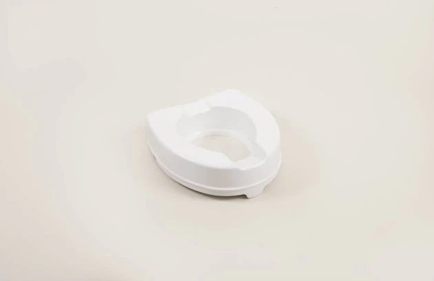 White toilet raiser seat on a light background.