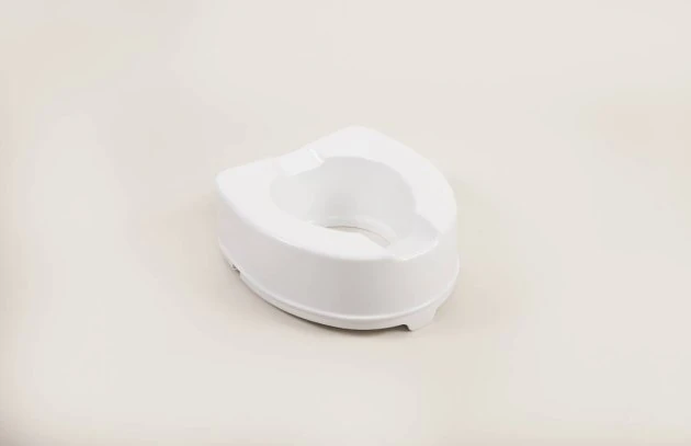 White toilet raiser seat on a plain background.
