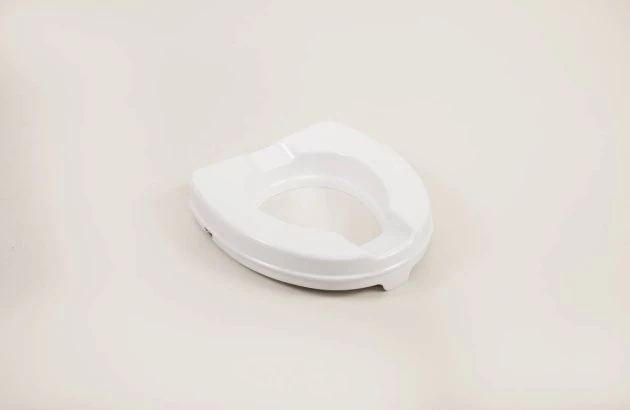 White elevated toilet seat on a plain background.