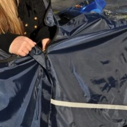 Person fastening a blue mobility scooter cape.