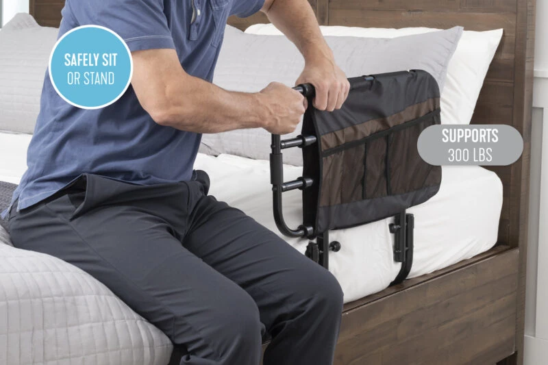 Person using the Stander EZ Adjust Bed Rail on a bed.