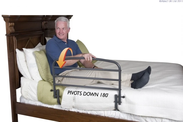 Man sitting on bed with a 30-inch bed support rail.
