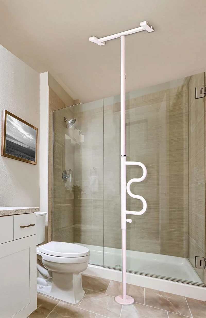 White security pole with curved grab bar next to a shower and toilet.