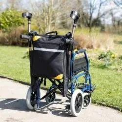 Mobility scooter bag with crutch holder attached to a wheelchair outdoors.