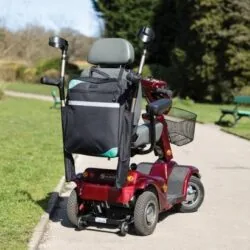 Mobility scooter with a black bag and crutch holder on a park path.
