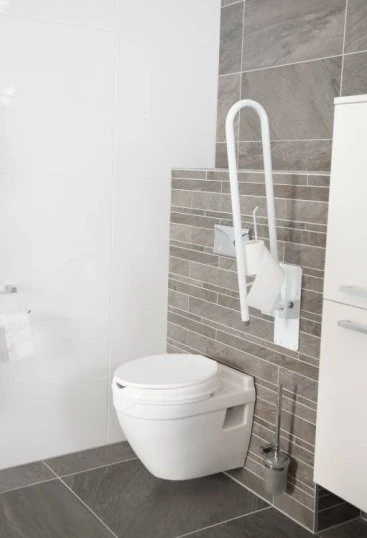 Folding bath rail mounted beside a toilet in a modern bathroom.