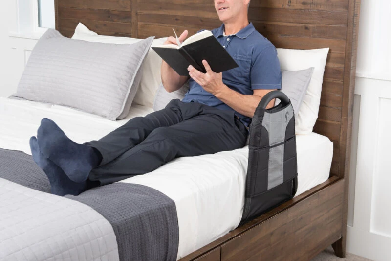 Person reading on bed with Stander Bedside Econorail attached.