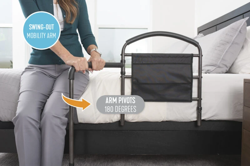 Person using a bed rail with a swing-out mobility arm.