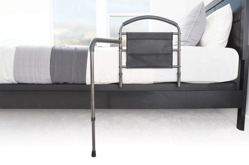 Mobility bed rail with swing-out arm attached to a bed.