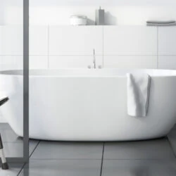 White bath stool with black legs next to a bathtub in a modern bathroom.