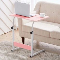 Pink over chair table with a laptop and mug beside a beige sofa.