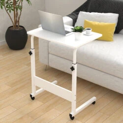 White over chair table with a laptop and plant beside a couch.
