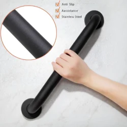 Hand holding a black bathroom safety handle on a wall.