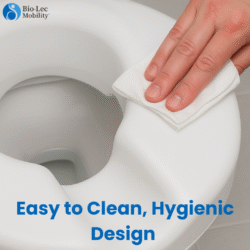 Hand cleaning a white raised toilet seat with a cloth.