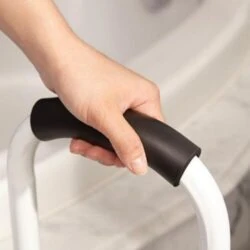 Close-up of a hand gripping the black handle of a safety step handrail.