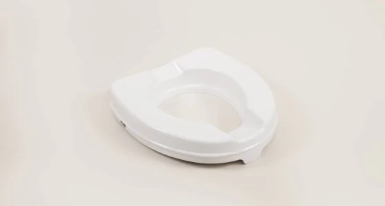White raised toilet seat without lid on a neutral background.