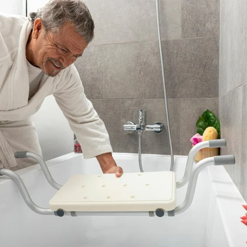 Person placing an adjustable suspended bath seat in a bathtub.