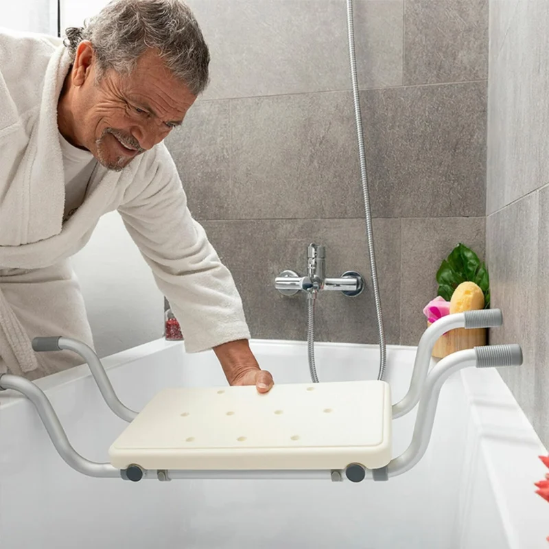 Person placing an adjustable suspended bath seat in a bathtub.
