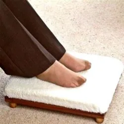 Feet resting on a white-covered wooden foot stool.