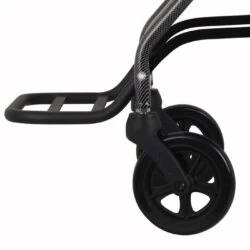Close-up of a wheelchair's footrest and front wheels.