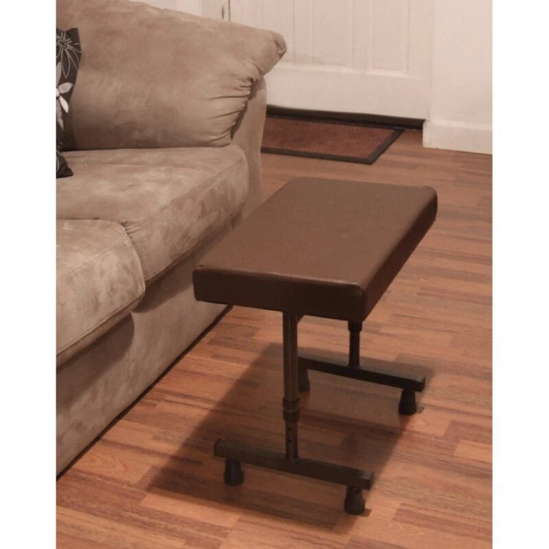 Brown adjustable leg rest stool beside a beige sofa on wooden flooring.