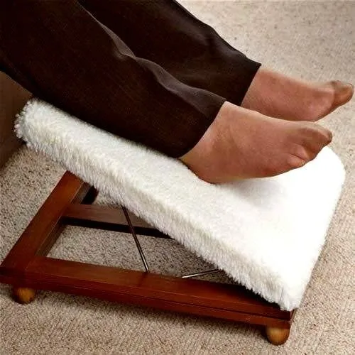 Feet resting on a white-covered wooden foot stool.