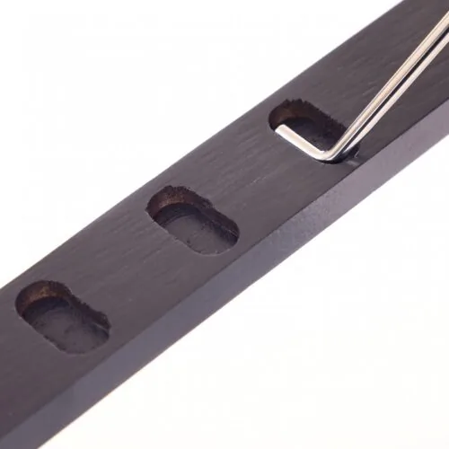 Close-up of a metal adjustment tool in a wooden bar with slots.