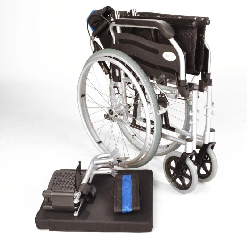 Folded lightweight wheelchair with detached leg rests and cushion.