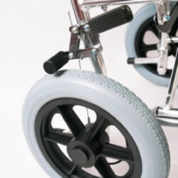 Close-up of a wheelchair's rear wheel and brake mechanism.