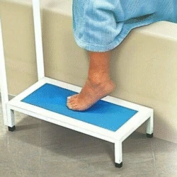 Person using a non slip bath step with handle, stepping onto a blue textured surface.