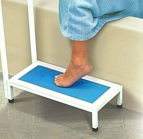 Person using a non slip bath step with handle, stepping onto a blue textured surface.