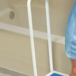 Person using a non-slip bath step with a handle next to a bathtub.