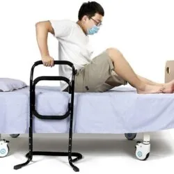 Person using a black standing aid on a bed.