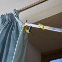 Reacher grabber holding a curtain on a rod.